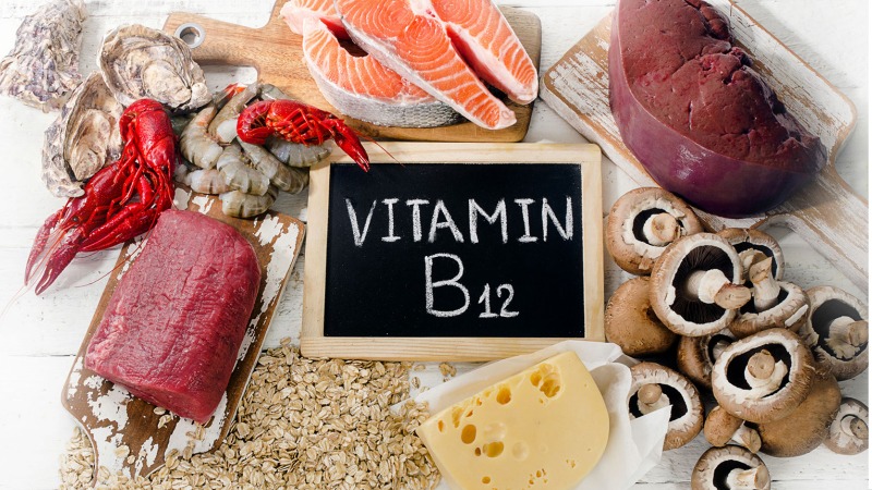 Vitamin B12 rich foods around a chalkboard with vitamin B12 written