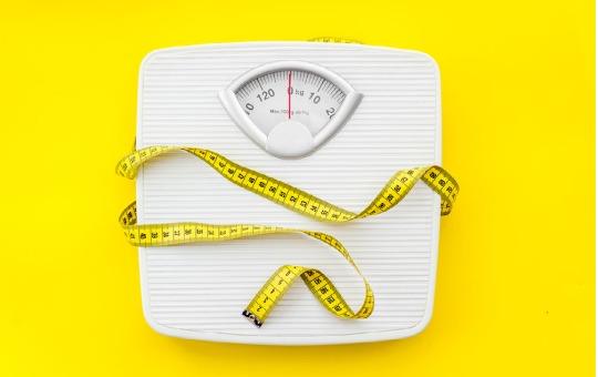 bright yellow background with measuring tape and a scale
