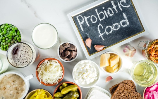 foods high in probiotics surrounding a chalk board with "probiotic foods" written on it.