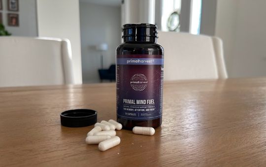 Tablets of primal mind fuel next to a bottle of supplements